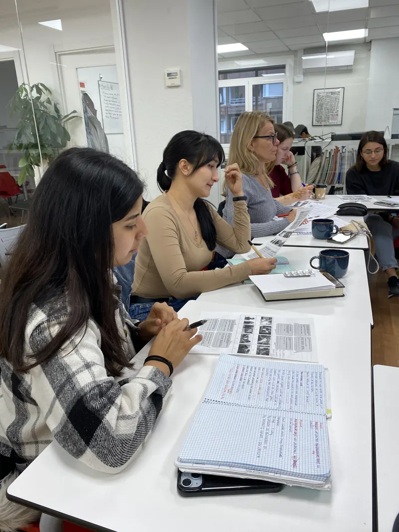 Alumnas siguiendo una actividad con las hojas de trabajo que incluye el curso, con sus tazas de té sobre la mesa